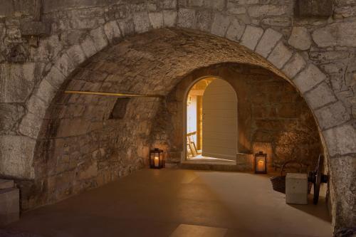 an archway in a stone wall with two candles at Luxury Jerini House with pool and wellness in Bajčići