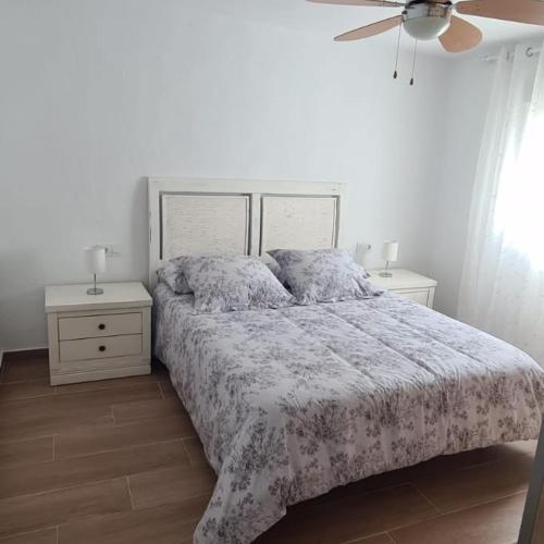 a white bedroom with a bed and two night stands at Rancho Blanco Tarifa La peña in Tarifa