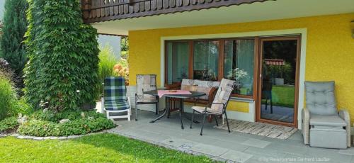 a patio with a table and chairs next to a house at Landhaus Simon in Gleißenberg