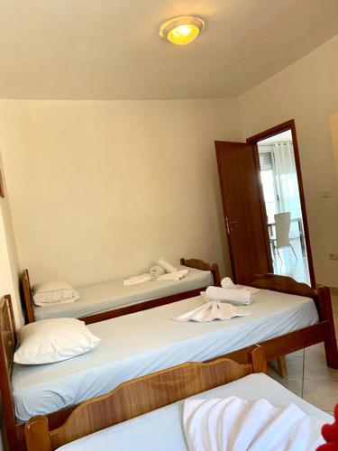 サランダにあるSaranda Port View Apartmentsのベッド2台と鏡が備わる客室です。