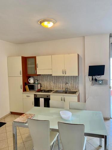una cucina con tavolo e sedie in una stanza di Saranda Port View Apartments a Sarandë