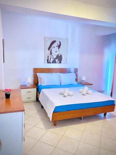 a bedroom with a large bed with blue and white sheets at Saranda Port View Apartments in Sarandë