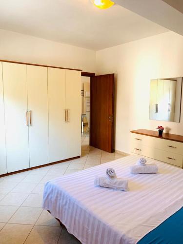a bedroom with a bed with two towels on it at Saranda Port View Apartments in Sarandë