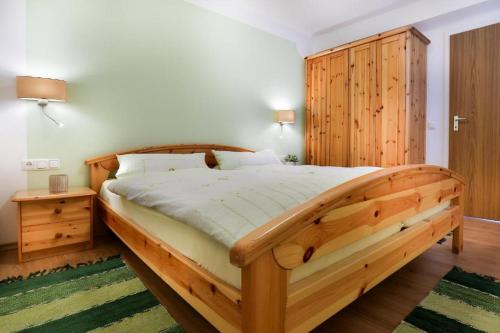 um quarto com uma cama de madeira e um armário de madeira em Ferienwohnung Haus Heimattreu em Schönau am Königssee