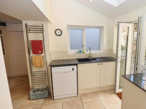 a kitchen with a sink and a dishwasher at Park Cottage in Matlock