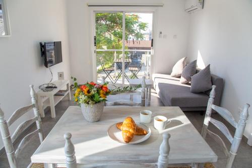 a living room with a table with a plate of food at Tikay Holiday Apts in Ayia Napa