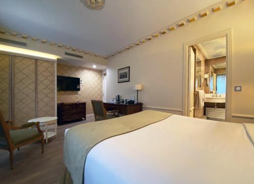 a hotel room with a large bed and a desk at Gavarni in Paris