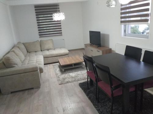 un salon avec une table et un canapé ainsi qu'une salle à manger dans l'établissement Apartmani Dojčinović, à Vranje