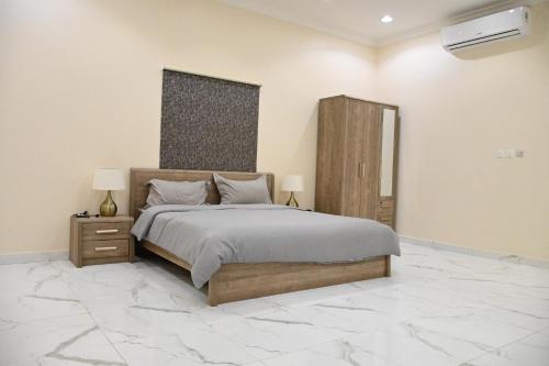 a bedroom with a large bed and a marble floor at SHALLY VILLAGE in Dammam