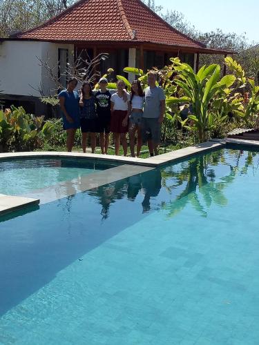 a group of people standing next to a swimming pool at Pier26 Bali Homestay in Nusa Dua