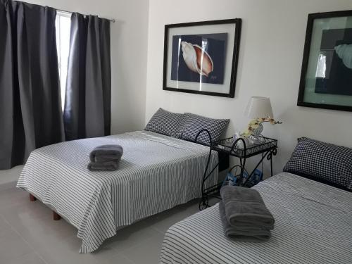 1 dormitorio con 2 camas, mesa y ventana en Cancun Blue Airport, en Cancún