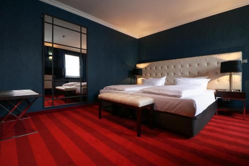 a bedroom with a large bed and a mirror at Hotel Haverkamp in Bremerhaven