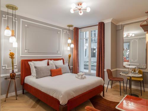 a bedroom with a large bed and a dining room at The Orange Haussmann in Paris