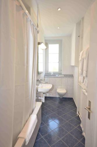 a bathroom with a sink and a toilet and a tub at 2BR flat near lake and central - Stardust 22 in Zurich