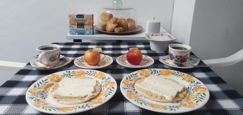 a table with plates of cake and cups of coffee at Hostel Metro Floresta Alojamiento in Medellín