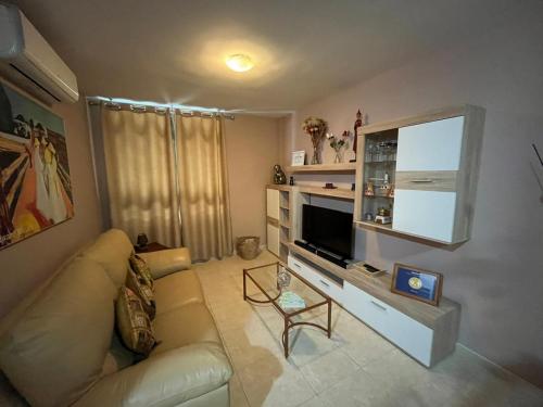sala de estar con sofá y TV de pantalla plana en PISO 20 en Candelaria