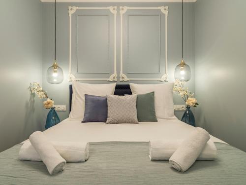 - un lit blanc avec des oreillers et 2 fenêtres dans l'établissement The Pompadour Suite, à Paris