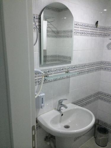 a white bathroom with a sink and a mirror at Mutado Hotel in Antalya