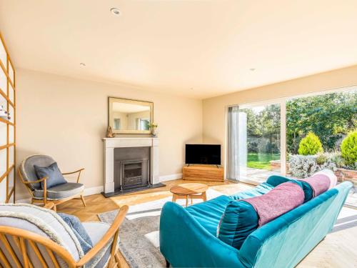 a living room with a blue couch and a fireplace at Stylish and fresh 4 bed beach house with garden - Pass the Keys in Chichester