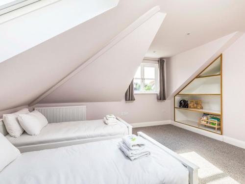 a attic room with a bed and a mirror at Pass the Keys Stylish and fresh 4 bed beach house with garden in Chichester