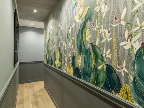 um corredor com um mural floral na parede em The Blue King Suite em Paris