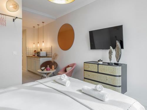 um quarto com uma cama e 2 toalhas brancas em Pink & Wood cocoon em Paris