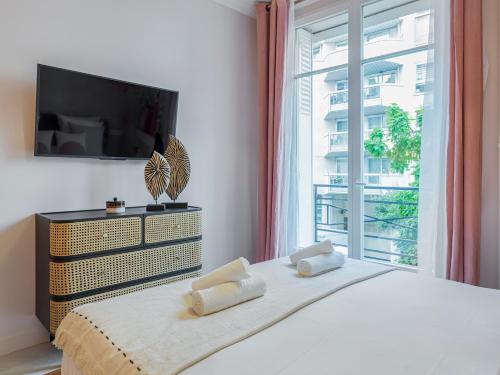 um quarto com uma cama, uma televisão e uma janela em Pink & Wood cocoon em Paris