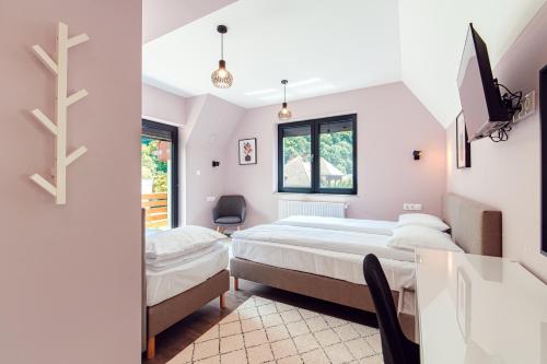 - une chambre avec 2 lits et un bureau dans l'établissement Selters Guesthouse, à Lueta