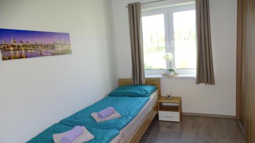 um pequeno quarto com uma cama e uma janela em Jenny home em Mojmírovce
