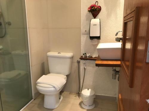 a bathroom with a toilet and a sink and a shower at Pousada Bosque das Araucárias in Campos do Jordão