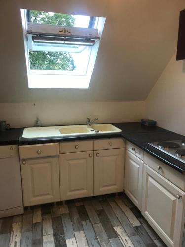 eine Küche mit Spüle und Fenster in der Unterkunft CHAMBRE FamilIale in Nandy
