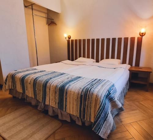 a bedroom with a large bed with a striped blanket at Kapteinu Osta in Salacgrīva