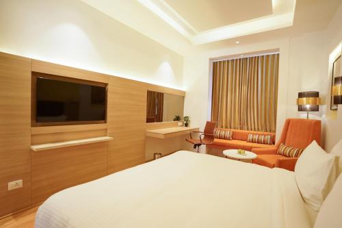 a hotel room with a bed and a television at Best Western Vrindavan in Vrindāvan