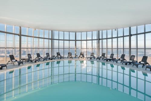 a swimming pool in a building with windows at Eurostars Oasis Plaza in Figueira da Foz