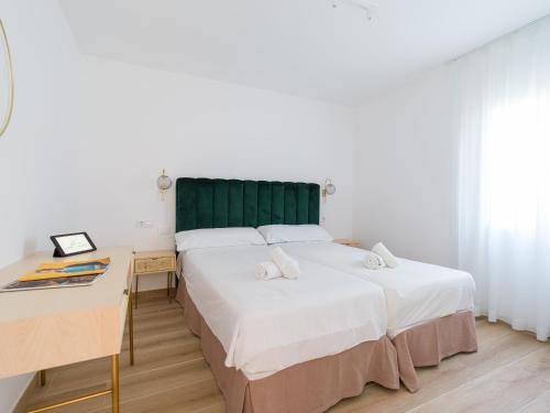 2 camas en una habitación con escritorio y 1 cama en HomeForGuest Moderno Apartamento con piscina en Corralejo, en Corralejo