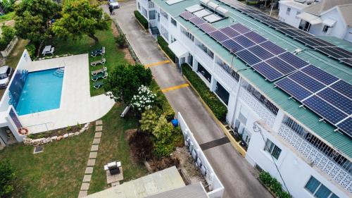 an aerial view of a house with solar panels on the roof at Adulo Apartments in Bridgetown