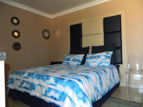 um quarto com uma cama com um edredão azul e branco em Sgobolo Guest House em Calcutta
