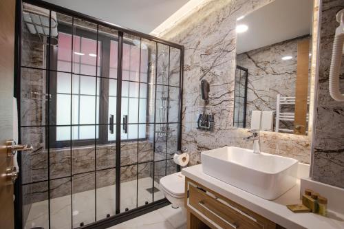 a bathroom with a sink and a toilet and a shower at bahçelievler hotels in Ankara