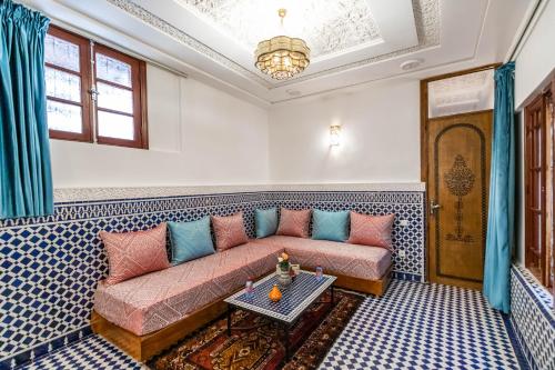 a living room with a couch and a table at Riad Dilar Fes & Spa in Fès