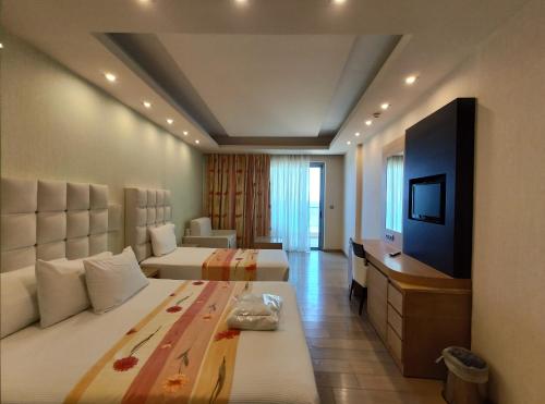 a hotel room with two beds and a television at Konstantinos Palace in Karpathos Town