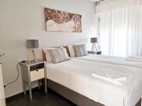 a bedroom with a white bed and a window at Unique Apartment Milfontes - Duna Parque Group in Vila Nova de Milfontes