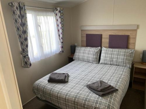 a bedroom with a bed with a purse on it at Paul’s place silversands in Lossiemouth