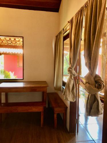 a room with a table and a window with curtains at Vila Hibisco Itacaré in Itacaré
