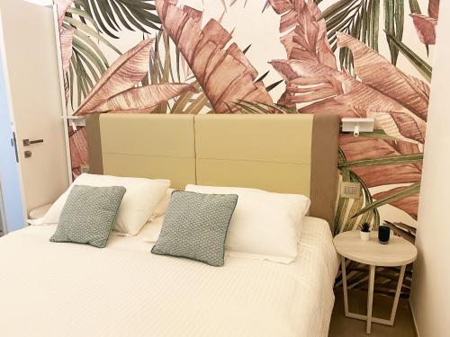 a bedroom with a bed with a tropical mural on the wall at Naturamare B&B in Villapiana