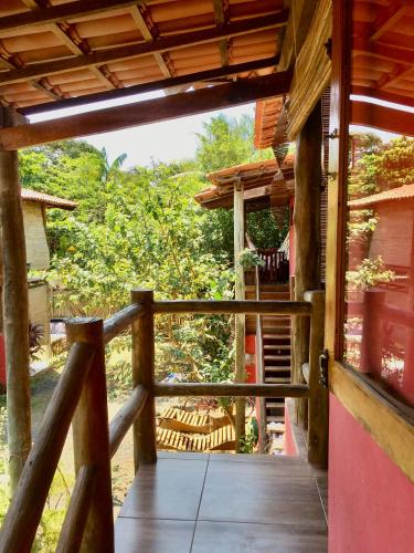 a porch of a house with a wooden railing at Vila Hibisco Itacaré in Itacaré