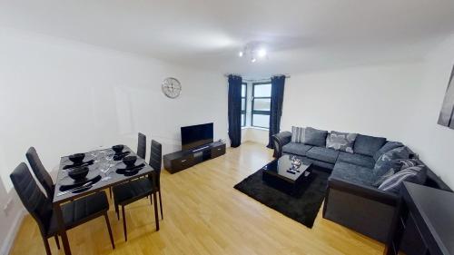 a living room with a couch and a table at OrangeApartments Riverside Drive,5 Minutes from City Centre in Aberdeen