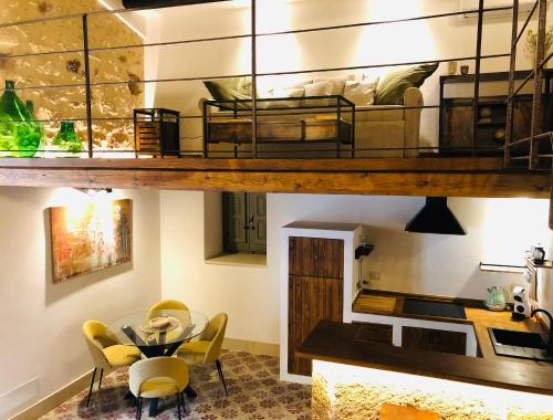 Pokój z łóżkiem na podwyższeniu ze stołem i krzesłami w obiekcie O'scià Loft w mieście Noto