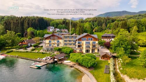 an aerial view of a large house on a lake at Hotel Stadler am Attersee in Unterach am Attersee