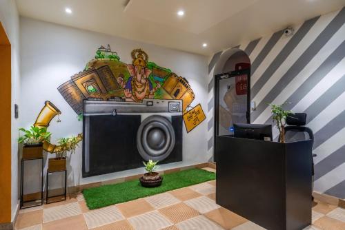 a room with a tv and a mural on the wall at Coliwo Un - Viman Nagar in Pune