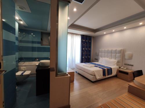 a hotel room with a bed and a bathroom at Konstantinos Palace in Karpathos Town